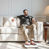 Man sits on couch with feet on the Homedics Shiatsu Deluxe Foot Massager with Heat