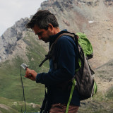 Man checks his pulse with the Homedics Premium Pulse Oximeter while hiking