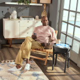Walnut | drift 21" wood stand displays the drift sand table next to a man while he relaxes in the afternoon